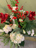 Festive flower arrangement with red amaryllis, white roses, berries and greenery by Joshua's Greenery