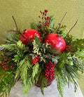 Festive floral arrangement with pomegranates, winter greens, and red berries from Joshua's Greenery Barrie Florist