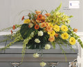 Colorful casket spray with yellow, orange, and green flowers from Joshua's Greenery Barrie Florist