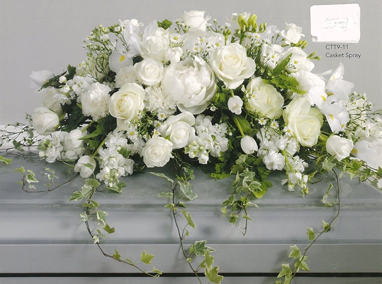 Elegant white casket spray with roses and greenery by Joshua's Greenery Barrie Florist