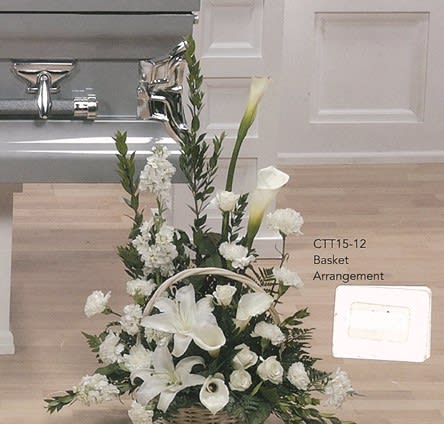 Elegant white floral basket arrangement beside silver casket, Joshua's Greenery Barrie Florist.