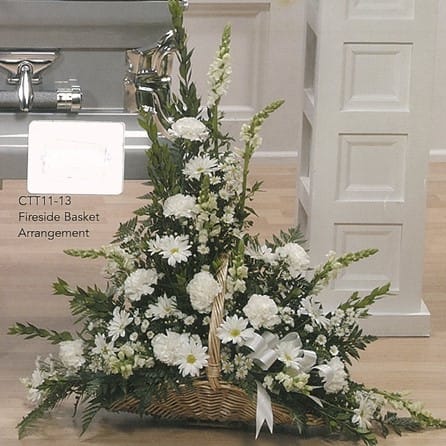 White floral fireside basket arrangement by Joshua's Greenery Barrie Florist on wooden floor