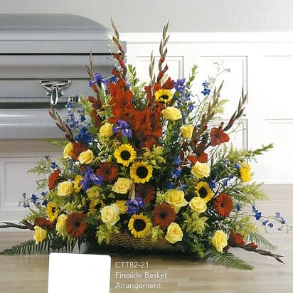 Colorful funeral flower arrangement with sunflowers, roses, and lilies by Joshua's Greenery