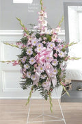 Standing funeral spray with pink daisies and bow, arranged by Joshua's Greenery Barrie Florist