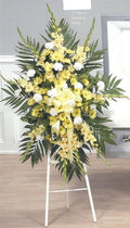 Yellow and white standing funeral spray with greenery on easel from Joshua's Greenery Barrie Florist
