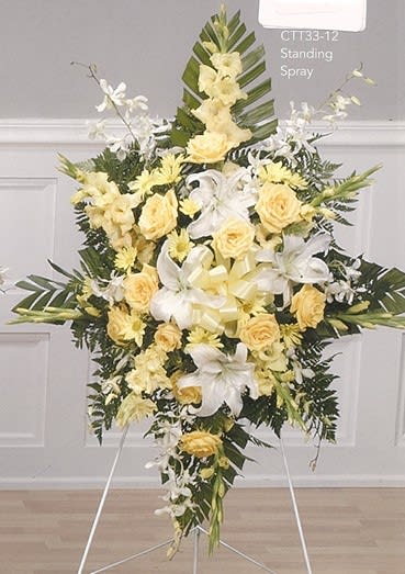 Yellow and white funeral standing spray with lilies and roses, floral arrangement by Joshua's Greenery