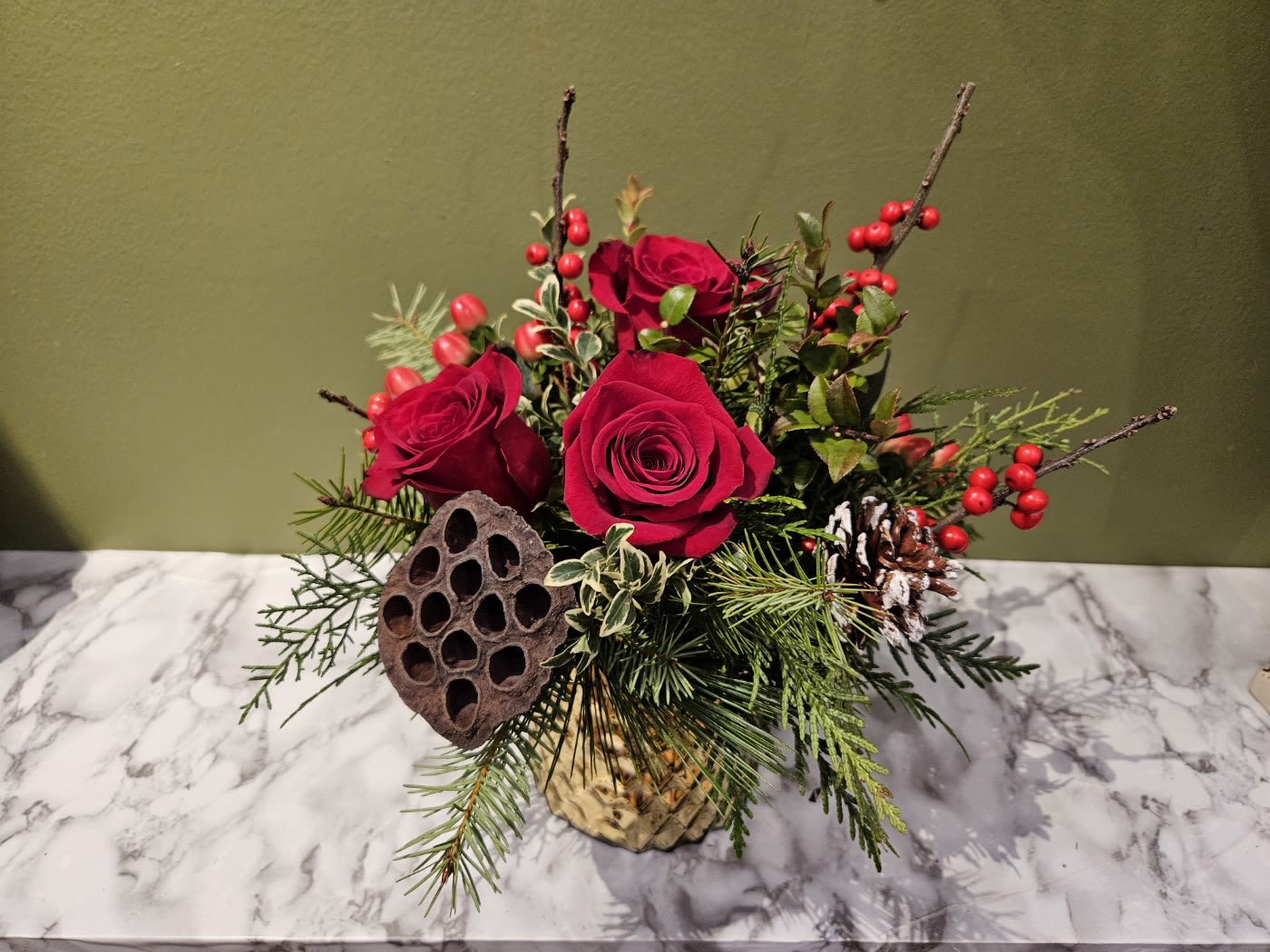 Festive floral arrangement with red roses, pine, and holiday accents in a gold vase, Barrie florist