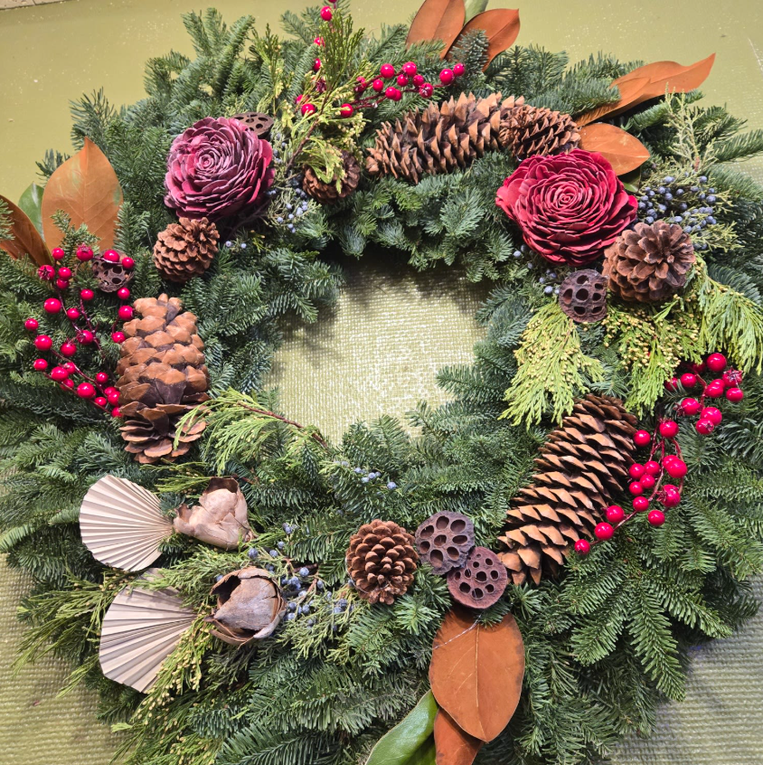 Festive evergreen wreath with pinecones, red berries, and florals, sold by Joshua's Greenery Barrie Florist