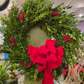 Holiday greenery wreath with red berries and large red bow at Joshua's Greenery-Barrie Florist