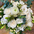 White rose bouquet with greenery from Joshua's Greenery Barrie Florist on wood surface