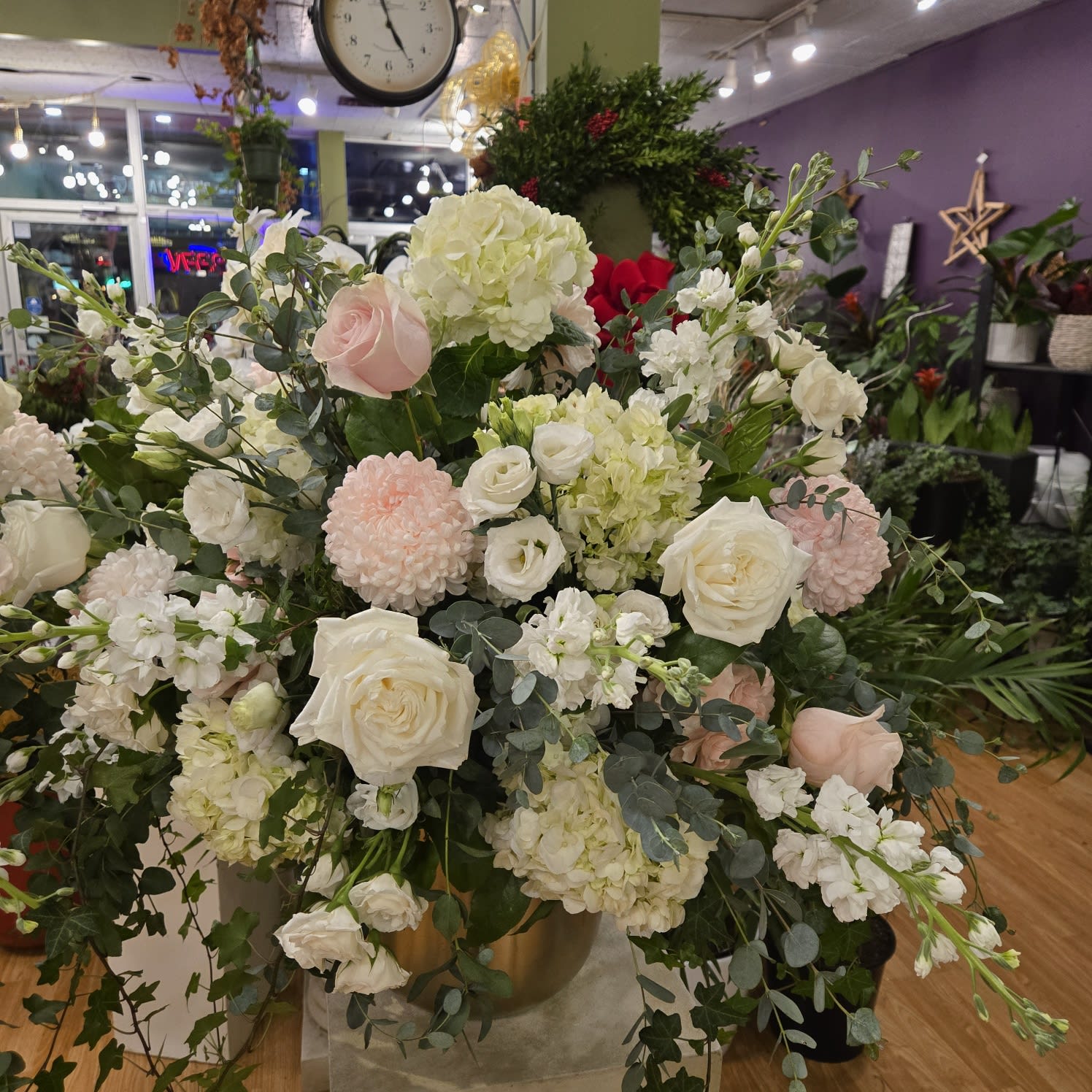 Elegant flower arrangement with white roses, hydrangeas, and greenery at Joshua's Greenery Barrie florist shop.