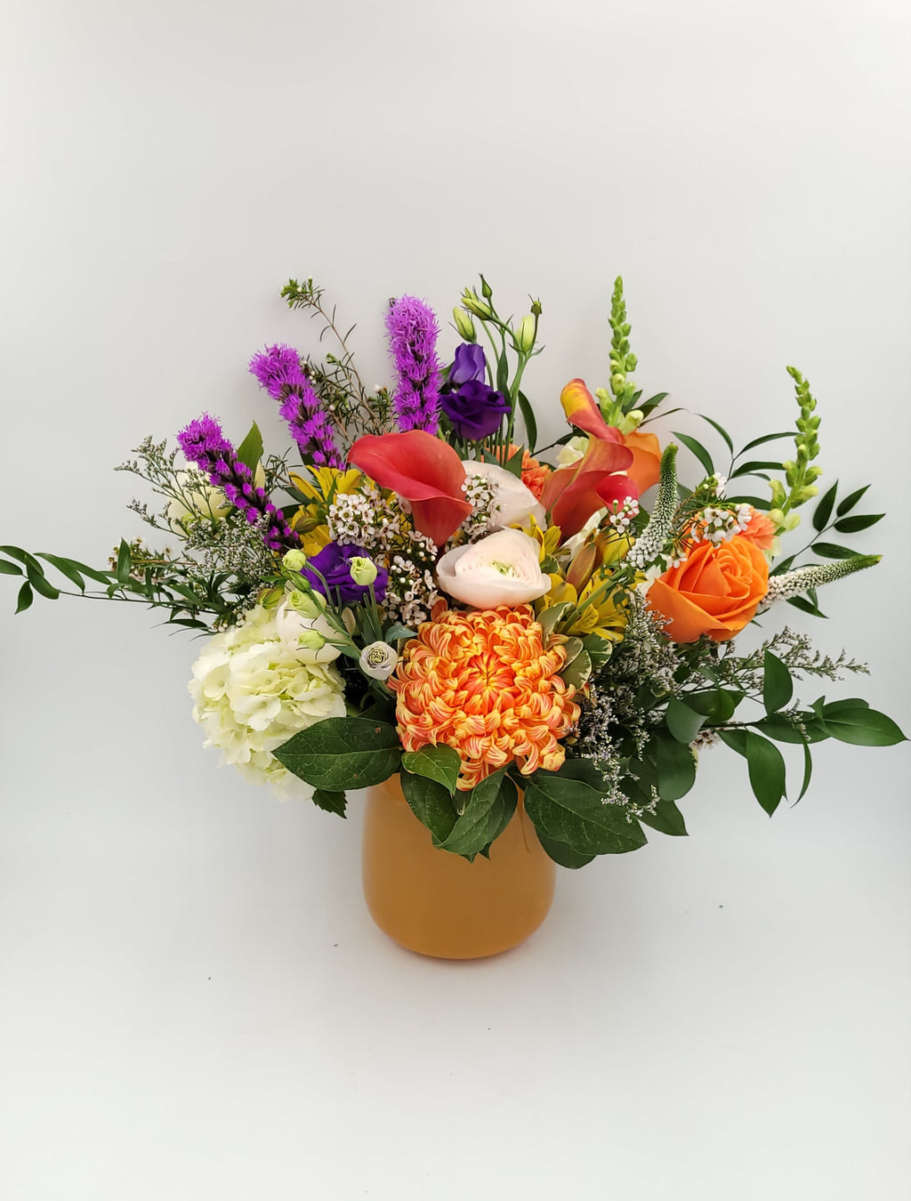 Colorful flower arrangement in orange vase from Joshua's Greenery Barrie Florist