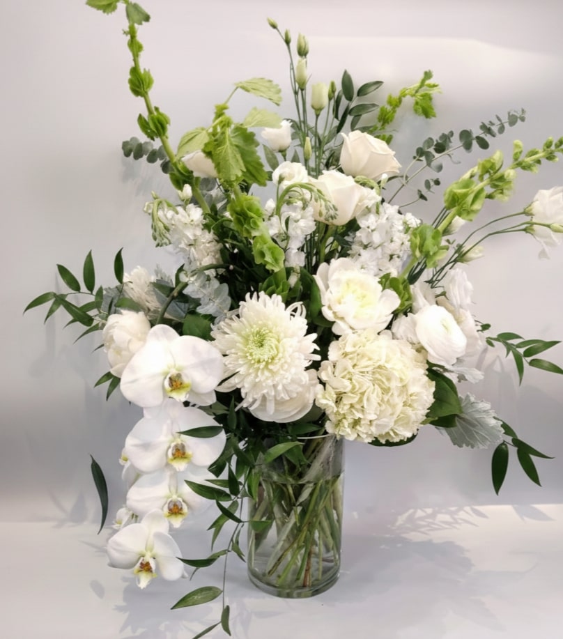 Elegant white flower arrangement with orchids, roses, and greenery in a glass vase from Joshua's Greenery Barrie Florist