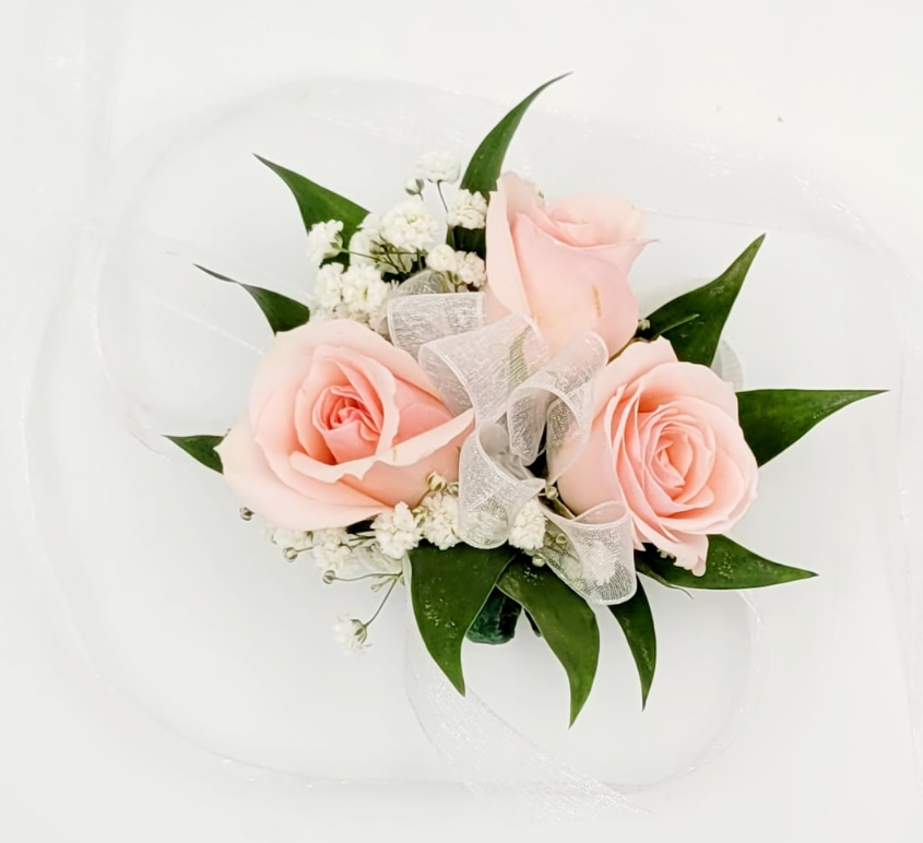 Pink rose corsage with white ribbon, greenery, and baby's breath from Barrie florist.