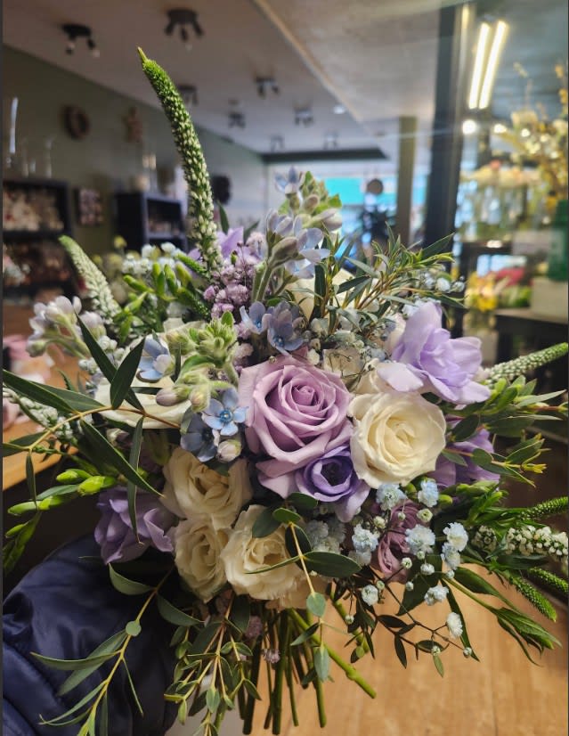 Hand-tied bouquet of purple and white roses with greenery at Joshua's Greenery Barrie florist.