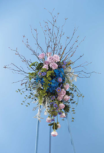 Elegant floral arrangement with pink roses, blue hydrangeas, and greenery on easel, Joshua's Greenery