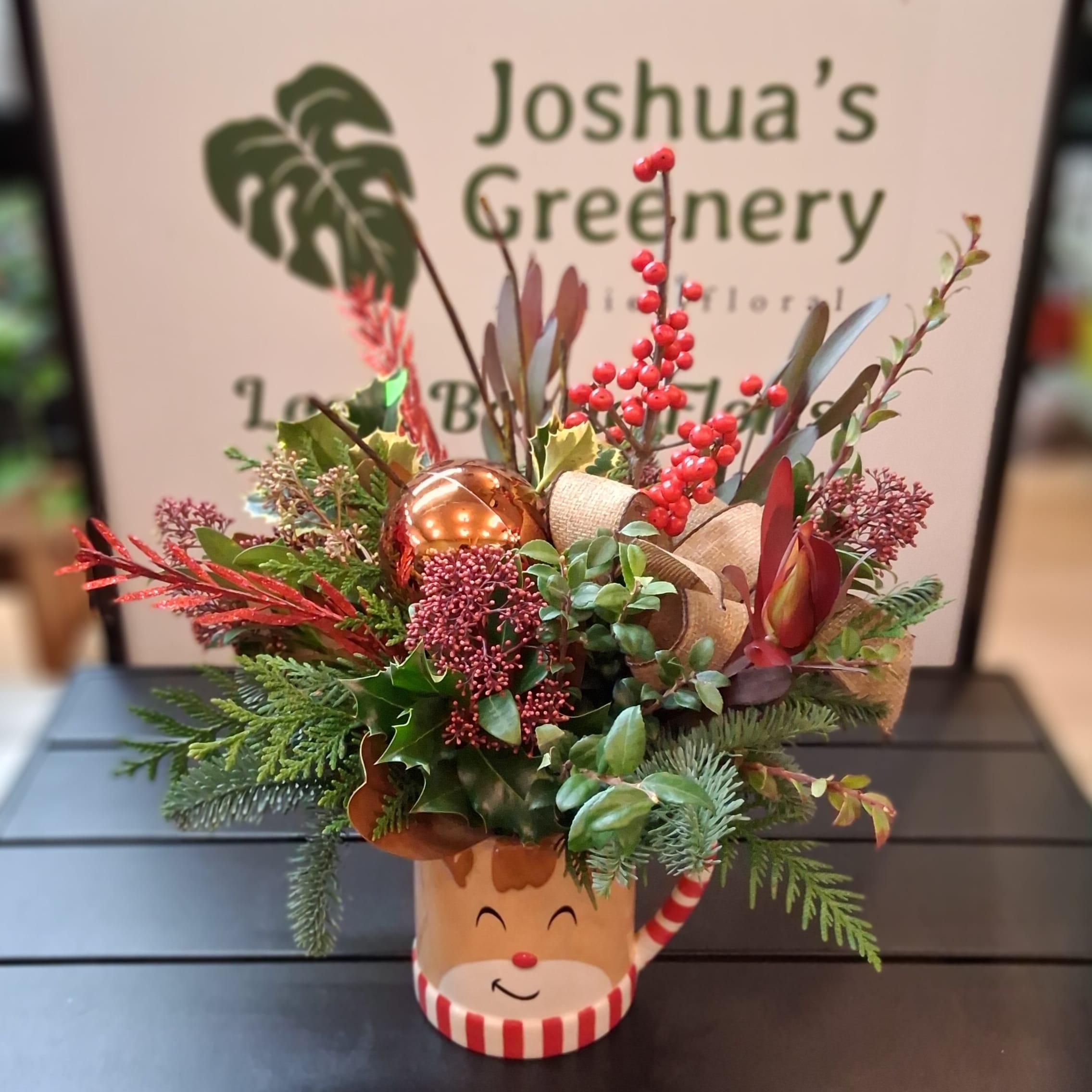 Festive holiday floral arrangement in a reindeer mug at Joshua's Greenery Barrie Florist