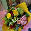 Colorful mixed flower bouquet with yellow calla lilies, pink, red, and green blooms, wrapped in pink and yellow paper, arranged by Joshua's Greenery Barrie Florist.