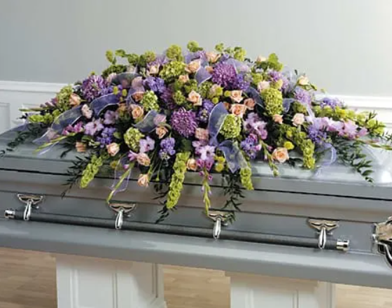 Lavender and peach funeral casket spray arrangement from Joshua's Greenery Barrie Florist